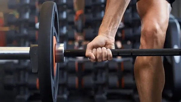 Main soulevant une barre de musculation, entraînement de force