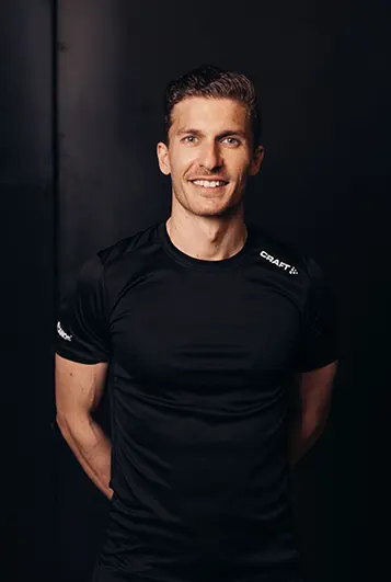 Homme coach souriant : Coach sportif Atlas Gym – accompagnement personnalisé et motivation.