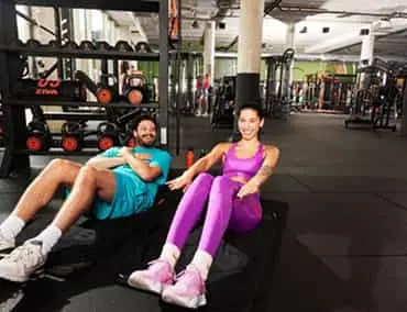 Deux femmes en salle de sport : Entraînement fonctionnel en duo – motivation et complicité.